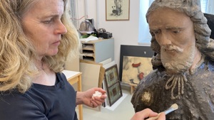Restaurátorka Krkonošského muzea Správy KRNAP Jana Skálová ošetřuje dřevěnou plastiku sv. Rocha z vrchlabského kostela, foto Radek Drahný, archiv Správy KRNAP