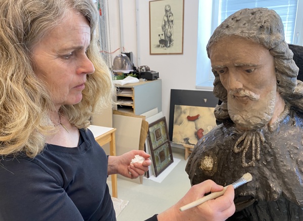 Restaurátorka Krkonošského muzea Správy KRNAP Jana Skálová ošetřuje dřevěnou plastiku sv. Rocha z vrchlabského kostela, foto Radek Drahný, archiv Správy KRNAP